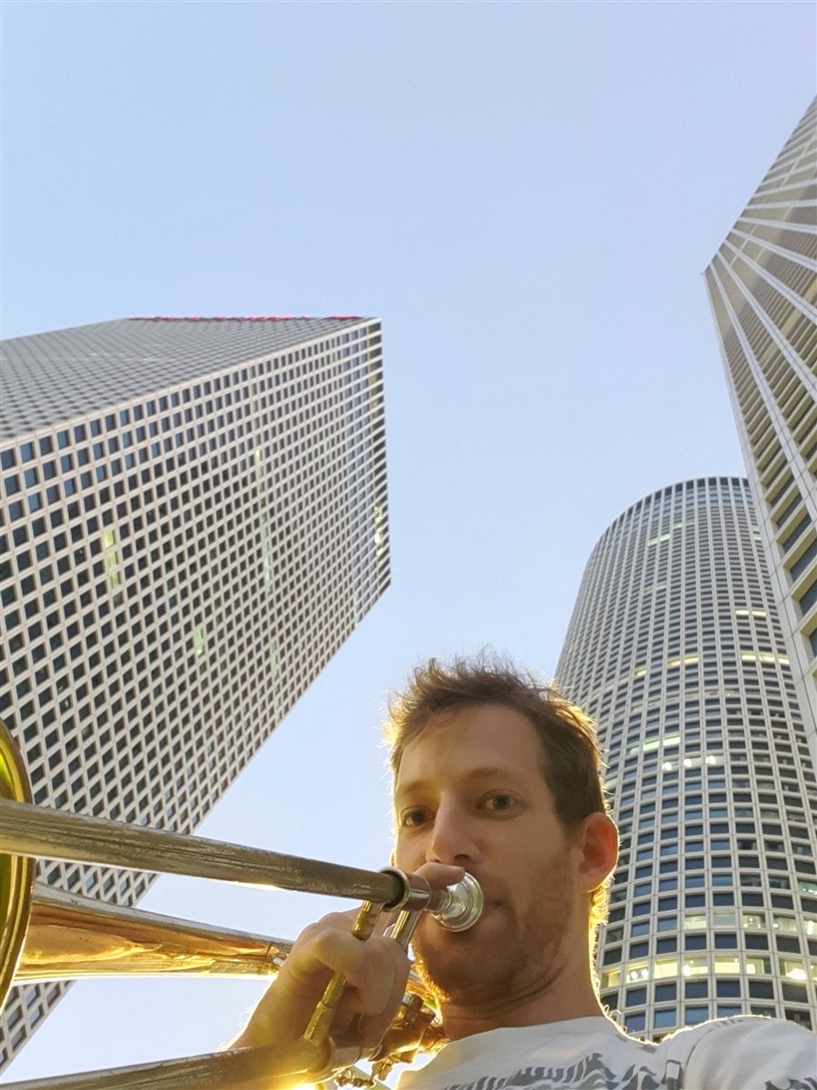 Amir Mano with his trombone outdoors